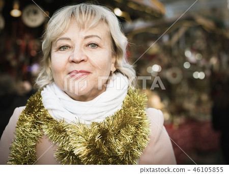 Positive female in tinsel on Christmas fair 46105855