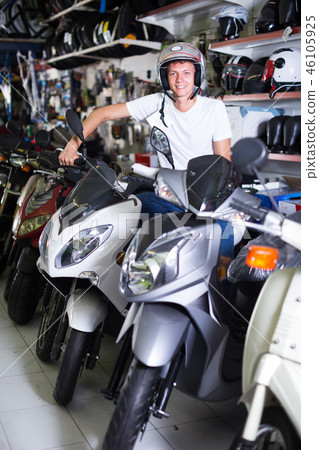 motorcyclist sitting on the motorbike with helmet 46105925