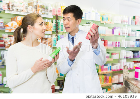 Joyful client asking pharmacist about medicines 46105939