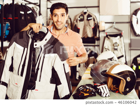 Man is demonstrating new jacket for motorbike in the store. Man is demonstrating new jacket for motorbike in the store. 46106042