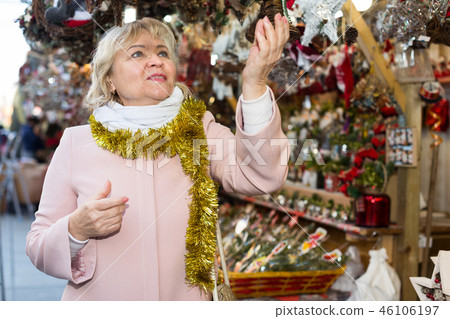 female in tinsel choosing decoration 46106197