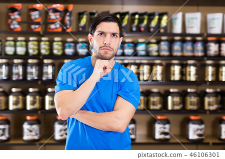 Young sportman standing near shelves in shop 46106301