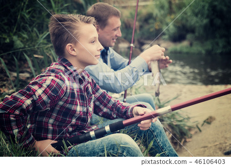 father and son fishing together on lake . 46106403