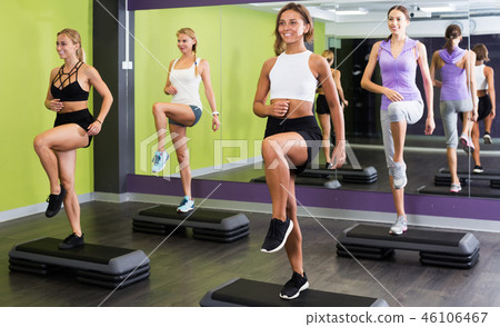Women doing step aerobics exercises Women doing step aerobics exercises 46106467