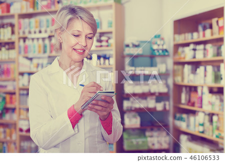 Female seller noting assortment in organic shop Female seller noting assortment in organic shop 46106533