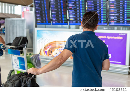 Man watching flight information display screen 46108811