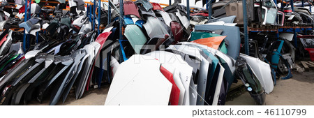 Auto parts market. On the ground are doors, bumpers and windshields. 46110799