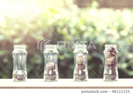 Stacked coins in 4 step growing on wooden table. 46111153