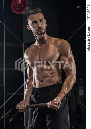 Handsome man with big muscles, posing at the camera in the gym Handsome man with big muscles, posing at the camera in the gym 46118006