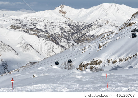Snow-covered ski slope in snowy mountains 46126708
