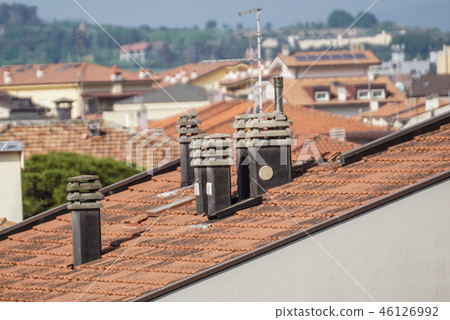 Old clay chimney pots and brick chimney stacks on old tiled roof complete with TV aerials in England Old clay chimney pots and brick chimney stacks on old tiled roof complete with TV aerials in England 46126992