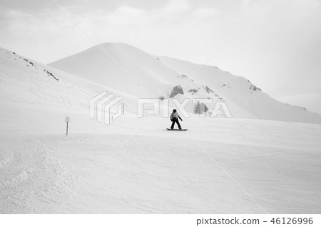 Snowboarder downhill on snowy ski slope Snowboarder downhill on snowy ski slope 46126996