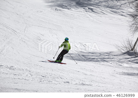 Skier downhill on snowy ski slope at sunny day Skier downhill on snowy ski slope at sunny day 46126999