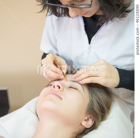 woman at salon for Professional eyebrow shaping woman at salon for Professional eyebrow shaping 46128890