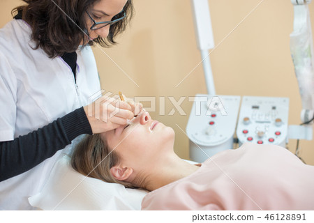woman at salon for Professional eyebrow shaping 46128891