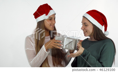 Female friends exchanging Christmas gifts, celebrating New Year 46129100