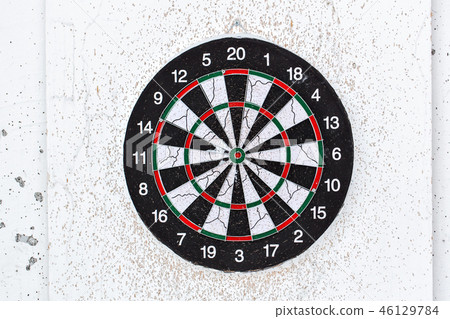 Empty old target dart board. Old used colorful board with lot of shots close up outdoors Empty old target dart board. Old used colorful board with lot of shots close up outdoors 46129784