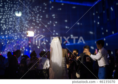 Happy bride dance at wedding party with guests and colour led lighting. 46135070