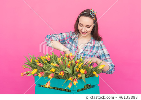 Brunette young woman with bunch of tulips on pink background 46135888