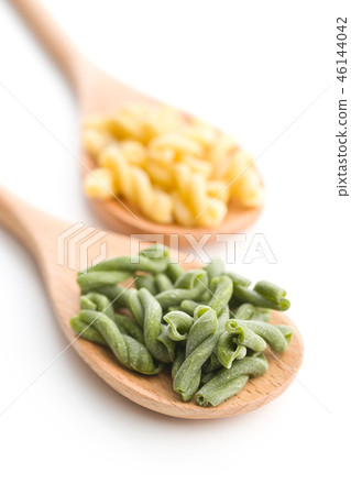 Uncooked spinach gemelli pasta. 46144042