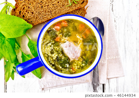 Soup with couscous and spinach in blue bowl 46144934