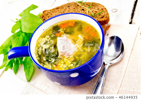 Soup with couscous and spinach in blue bowl Soup with couscous and spinach in blue bowl 46144935