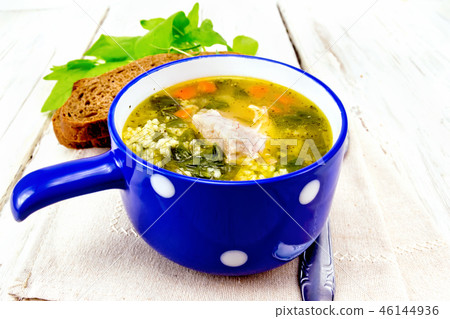 Soup with couscous and spinach in blue bowl 46144936