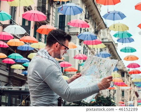 Handsome man with a tourist map on a cloudy day 46152289