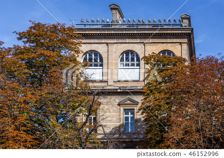 Brick building covered by orange leaf trees Brick building covered by orange leaf trees 46152996