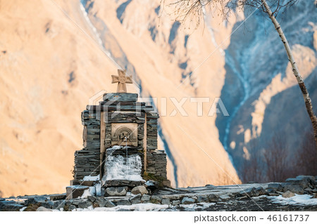 Stepantsminda, Gergeti, Georgia. Cross On Stones And Cold Minera Stepantsminda, Gergeti, Georgia. Cross On Stones And Cold Minera 46161737