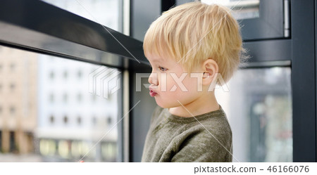 Boy sitting on the window near panoramic window Boy sitting on the window near panoramic window 46166076