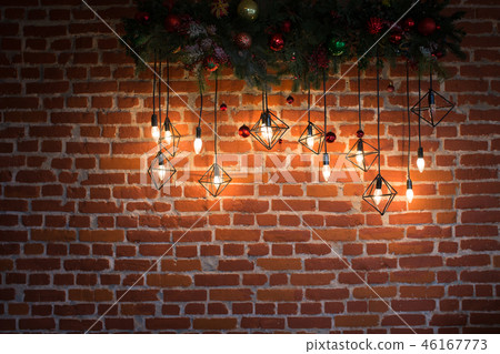 Brick wall with light bulbs and New Year's decoration 46167773