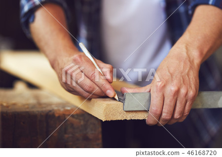 A carpenter uses a framing square 46168720