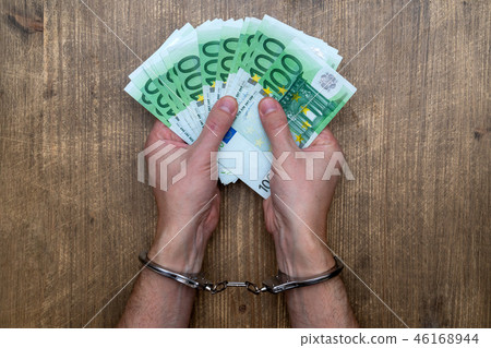 Hands in handcuffs with  money 46168944