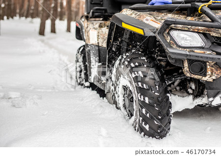 Close-up ATV 4wd quad bike in forest at winter. 4wd all-terreain vehicle stand in heavy snow with 46170734