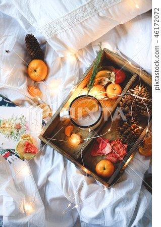 Christmas background dry oranges, sweet tangerines in a box, coffee in a white mug. Christmas background dry oranges, sweet tangerines in a box, coffee in a white mug. 46172072