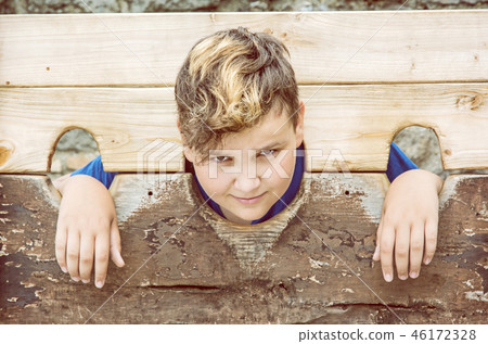Young caucasian boy in medieval pillory 46172328