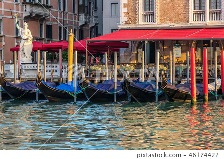 Gondolas near an italian street cafe in the Grand Canal of Venic Gondolas near an italian street cafe in the Grand Canal of Venic 46174422