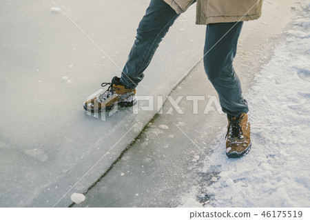 Trying the danger of the foot, testing the thin ice near the shore. A pair of lovers walk with a 46175519