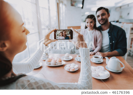 Mother Photographs Dad with Daughter on Cellphone Mother Photographs Dad with Daughter on Cellphone 46176396