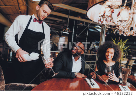 Waiter Pouring Wine to Glass Couple in Restaurant 46182232
