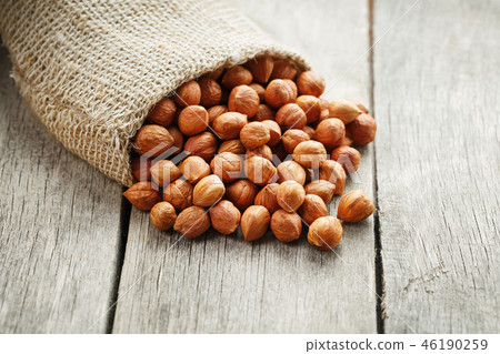 Chiselled hazelnuts in a bag of burlap on a gray Chiselled hazelnuts in a bag of burlap on a gray 46190259