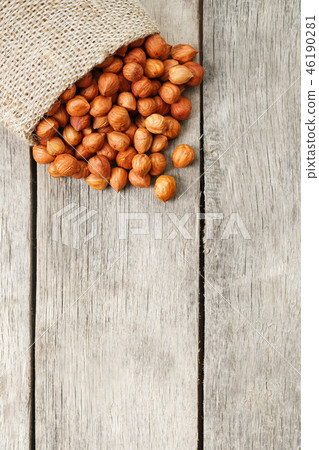 Chiselled hazelnuts in a bag of burlap on a gray Chiselled hazelnuts in a bag of burlap on a gray 46190281