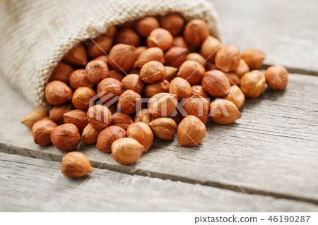 Chiselled hazelnuts in a bag of burlap on a gray Chiselled hazelnuts in a bag of burlap on a gray 46190287