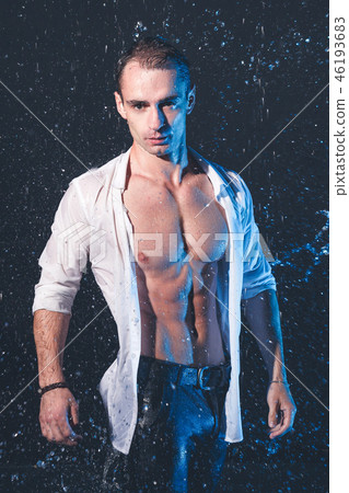 Fresh portrait of muscular man with water splashes on dark background. Fresh portrait of muscular man with water splashes on dark background. 46193683