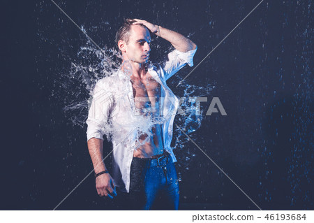 Fresh portrait of muscular man with water splashes on dark background. 46193684