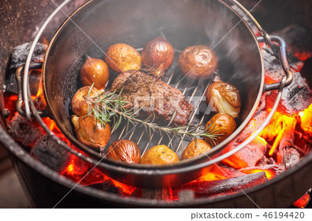 Dodge oven with charcoal fire Cooking in a Dutch oven Dodge oven with charcoal fire Cooking in a Dutch oven 46194420