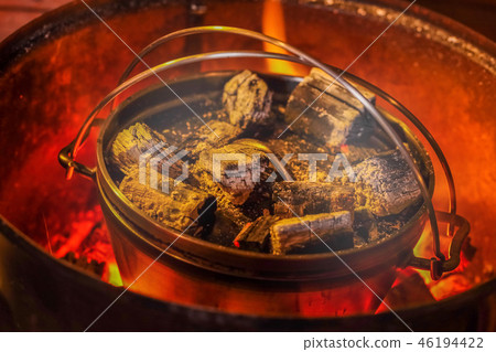 Dodge oven with charcoal fire Cooking in a Dutch oven Dodge oven with charcoal fire Cooking in a Dutch oven 46194422
