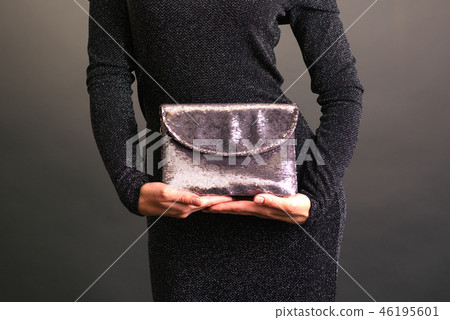 Young woman holding a shining clutch  46195601