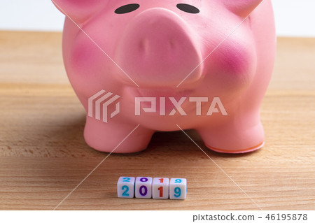 Year 2019 financial goal, happy smiling pink piggy bank with wooden cube block with number 2019 on Year 2019 financial goal, happy smiling pink piggy bank with wooden cube block with number 2019 on 46195878